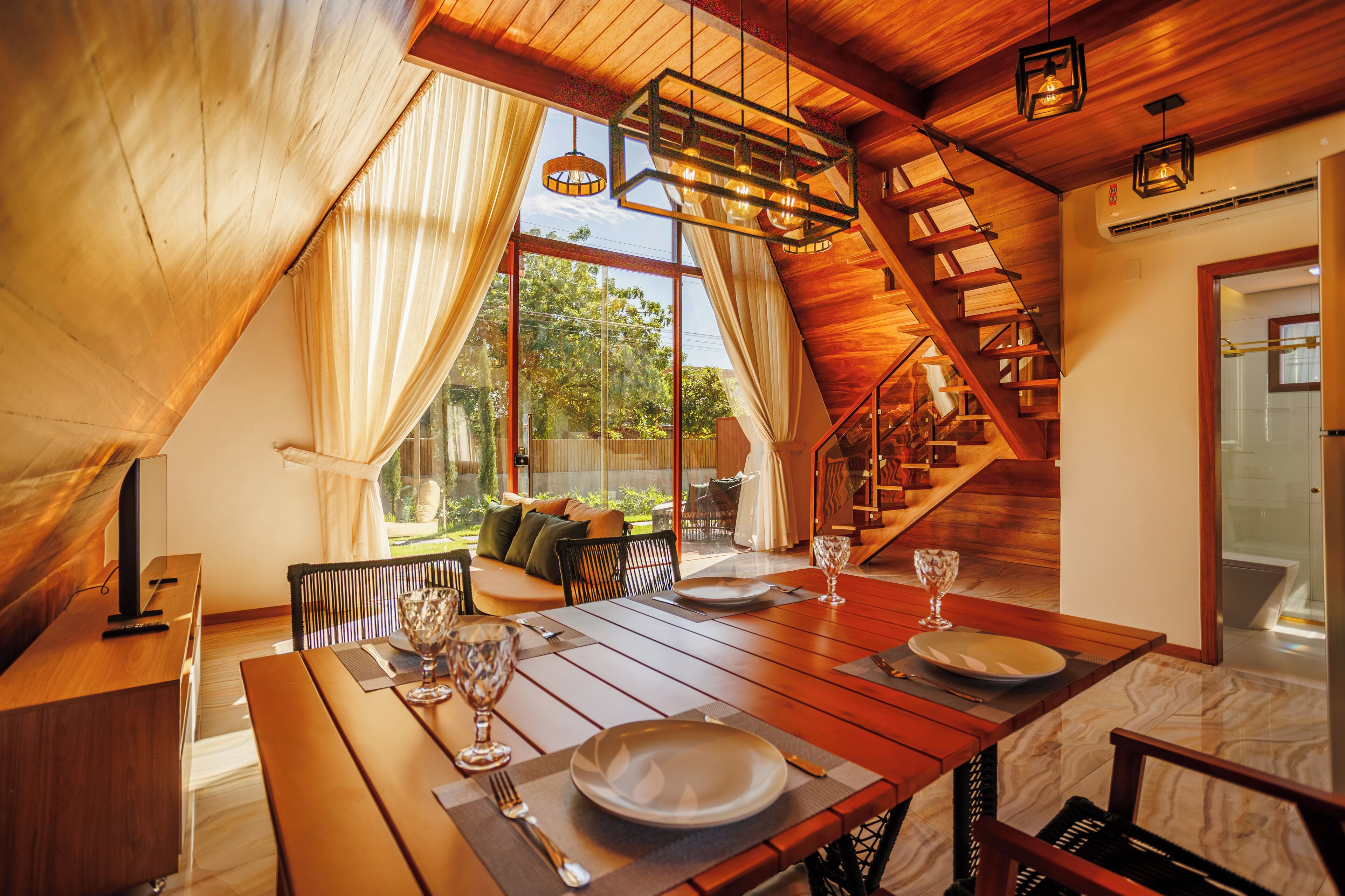 A dining area with a wooden table, chairs, and a view of the outdoors.