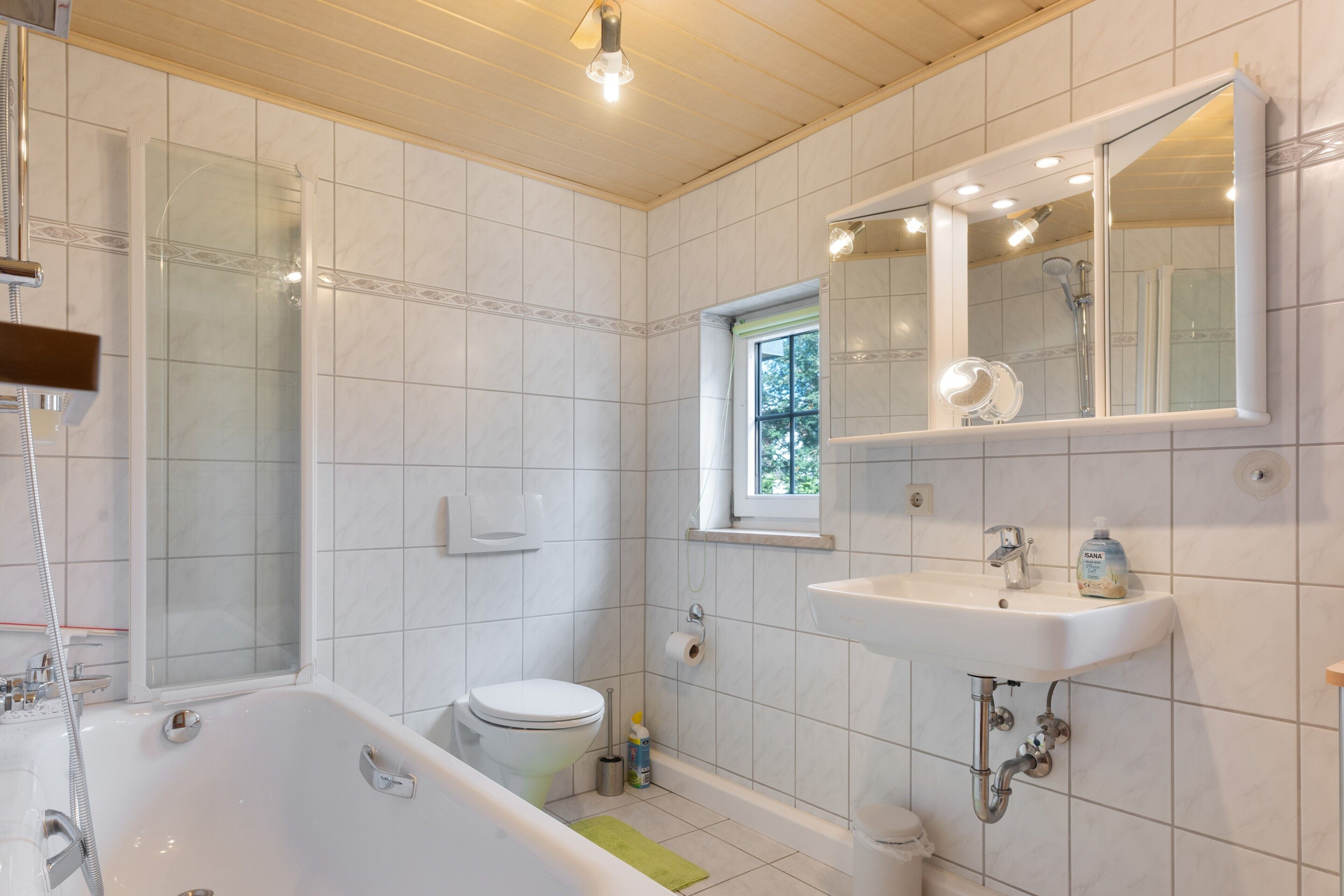 A modern bathroom with a bathtub, toilet, and sink.
