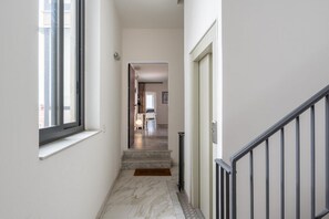 A narrow hallway with a marble floor, a welcome mat, and a staircase leading to another room. - A modern and welcoming 70-square-meter open space apartment, ideal for three people, located on the first floor of a renovated building with an elevator.The property enjoys a strategic location, just a 20-minute walk from Catania's city center and all it (Catania)