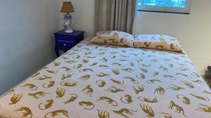 Ett hotellrum med en säng, ett nattduksbord med en lampa och ett fönster med utsikt över staden.
