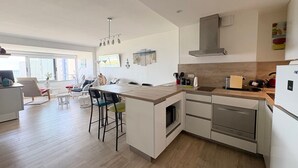 Une cuisine moderne dotée d’un îlot central, d’un four encastré et d’appareils électroménagers en acier inoxydable.
