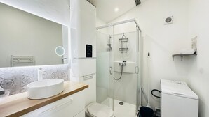 A modern bathroom with a glass-enclosed shower, a white sink, and a compact toilet. - Bright city centre apartment - 3 guests (Fouras)