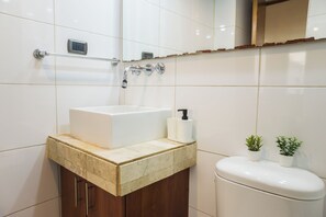 A bathroom with a white sink, a towel rack, a toilet, and two potted plants. - Providencia Moderno 2D 5 huespedes (Providencia)