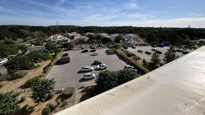 Un parking contenant plusieurs voitures, entouré de bâtiments résidentiels et de verdure.