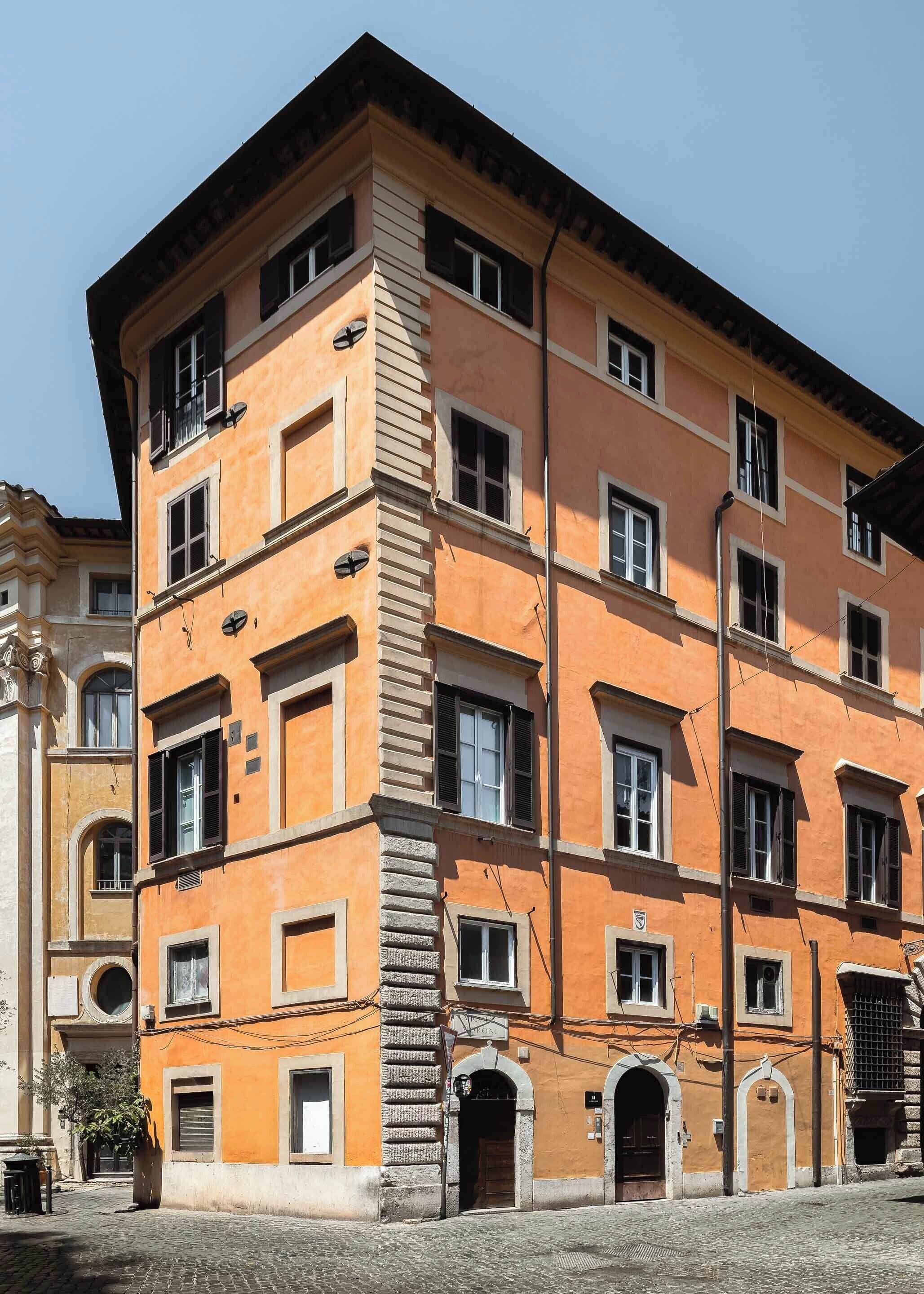 Un edificio a più piani con uno stile architettonico classico, caratterizzato da portali ad arco e una scala centrale.