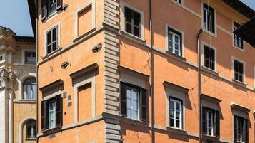 Un edificio a più piani con uno stile architettonico classico, caratterizzato da portali ad arco e una scala centrale.