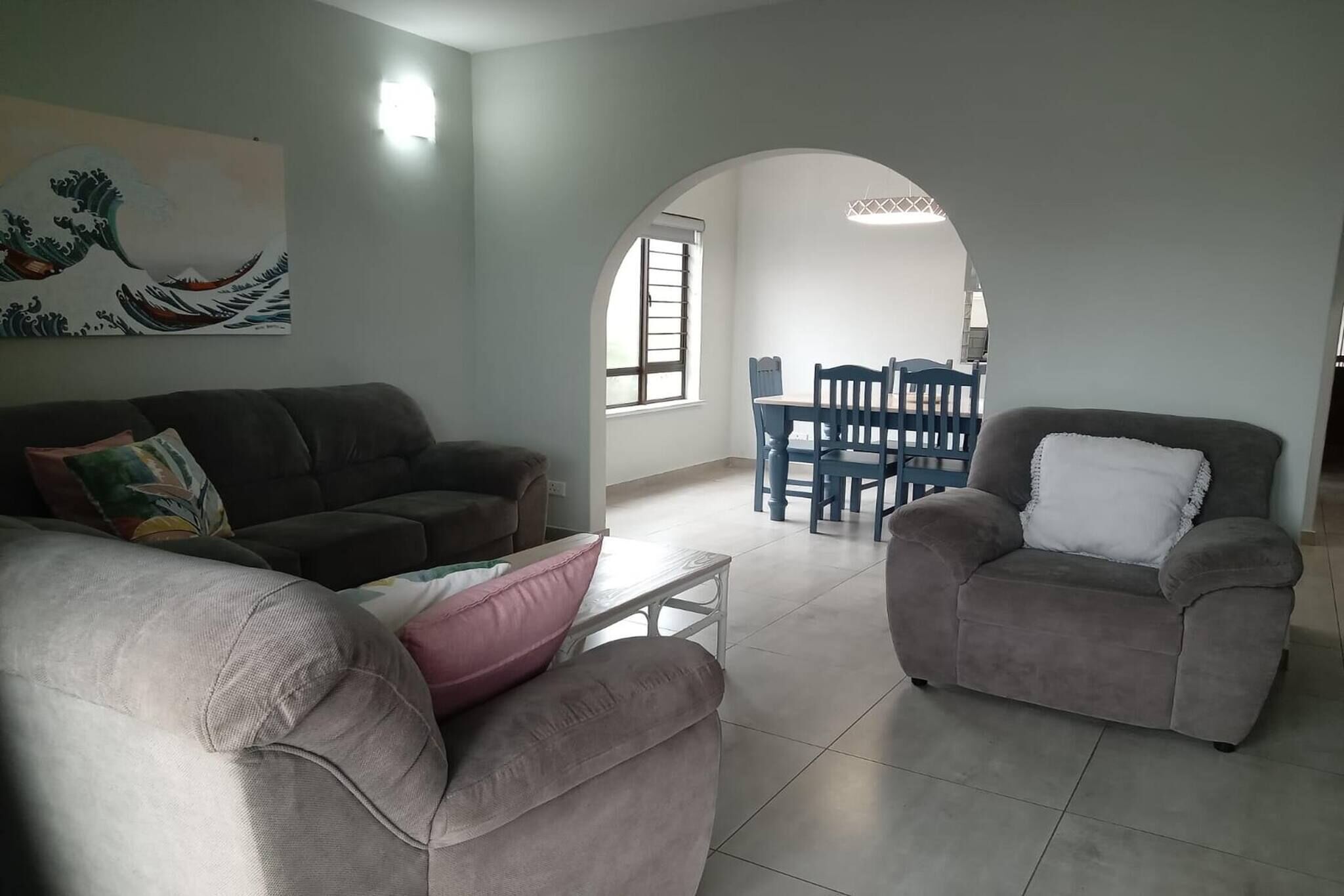 Un salon avec un canapé, un fauteuil et une table à manger.