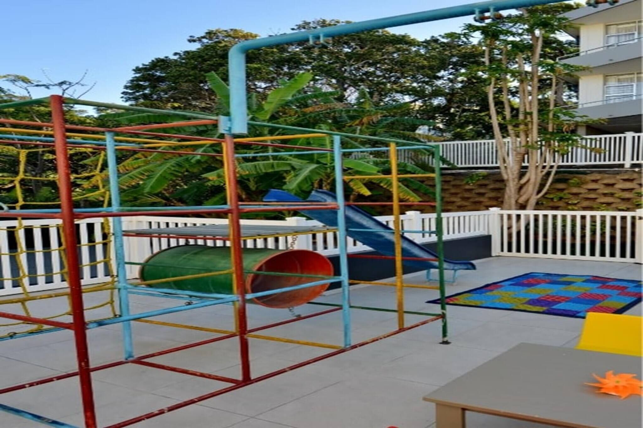 A playground with a slide, a climbing structure, and a ball pit.