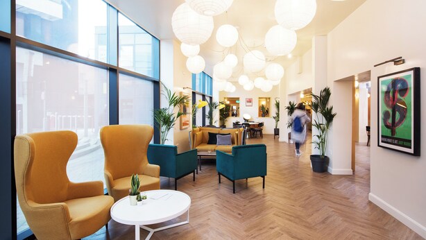 A spacious lobby with modern furniture, large windows, and decorative lighting. - Student Only Sky Plaza (Leeds)