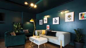 A modern living room with a sofa, armchair, coffee table, and decorative items on the wall. - Student Only Sky Plaza (Leeds)