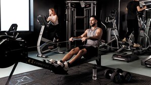 A gym with exercise equipment, a large window, and a water bottle on the floor. - Student Only Sky Plaza (Leeds)