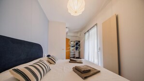 A bedroom with a bed, pillows, a hanging light fixture, a wardrobe, and a closet with shelves. - TD Terrazza Giulia Monopoli City Center (Monopoli)