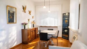 Un coin repas comprenant une table en bois, des chaises, un buffet et des éléments décoratifs muraux.