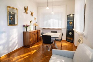Ein Essbereich mit Holztisch, Stühlen, einem Schrank und Wanddekoration.