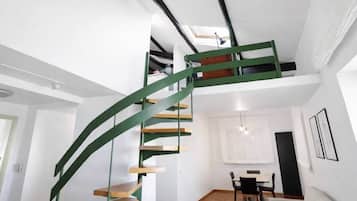 Ein modernes Interieur mit einer Wendeltreppe, einem Essbereich und einem Wohnzimmer.