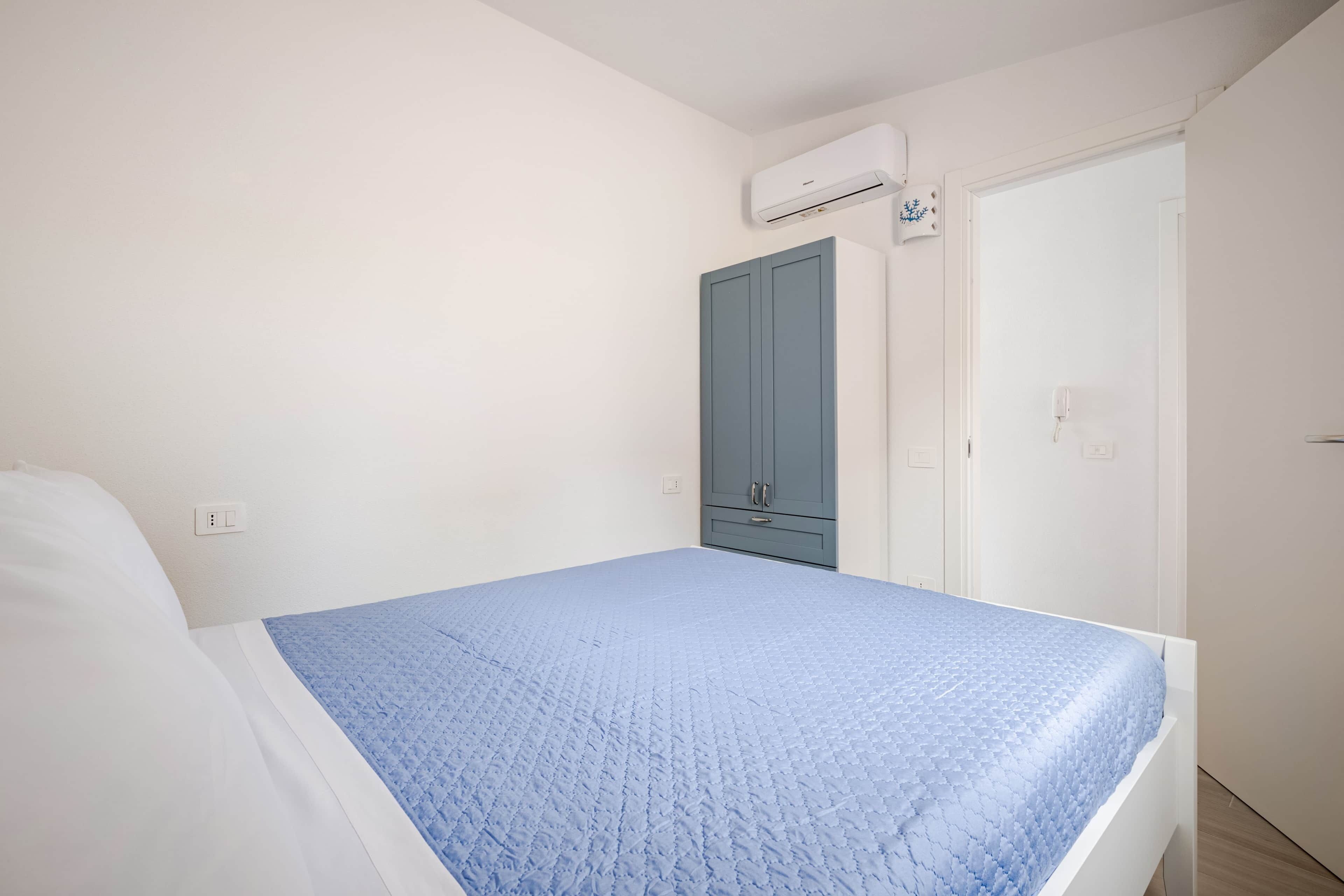 Ein Schlafzimmer mit einem Bett, einem Kleiderschrank und einer Klimaanlage.