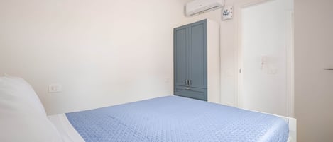 Ein Schlafzimmer mit einem Bett, einem Kleiderschrank und einer Klimaanlage.