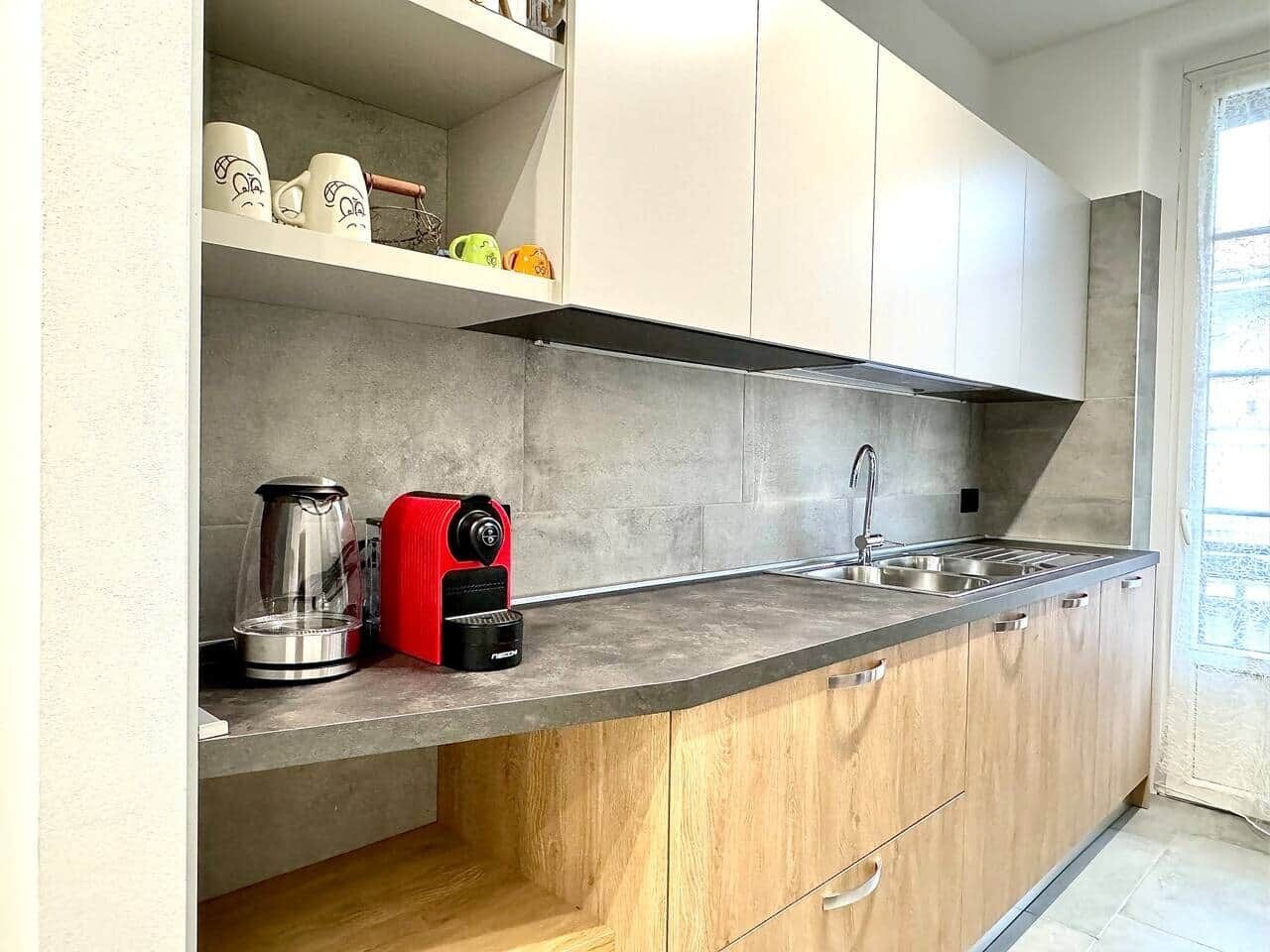 A kitchen with a built-in stove, a sink, and a coffee maker.