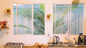 Une cuisine équipée d’une cuisinière, d’une bouilloire et d’une table agrémentée d’un vase.
