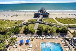 Un complex turístic amb piscina, platja i moll.