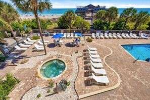 A pool area with lounge chairs, a hot tub, and a view of the beach. - High Seas by Casanita - Oceanfront Suite (Myrtle Beach)