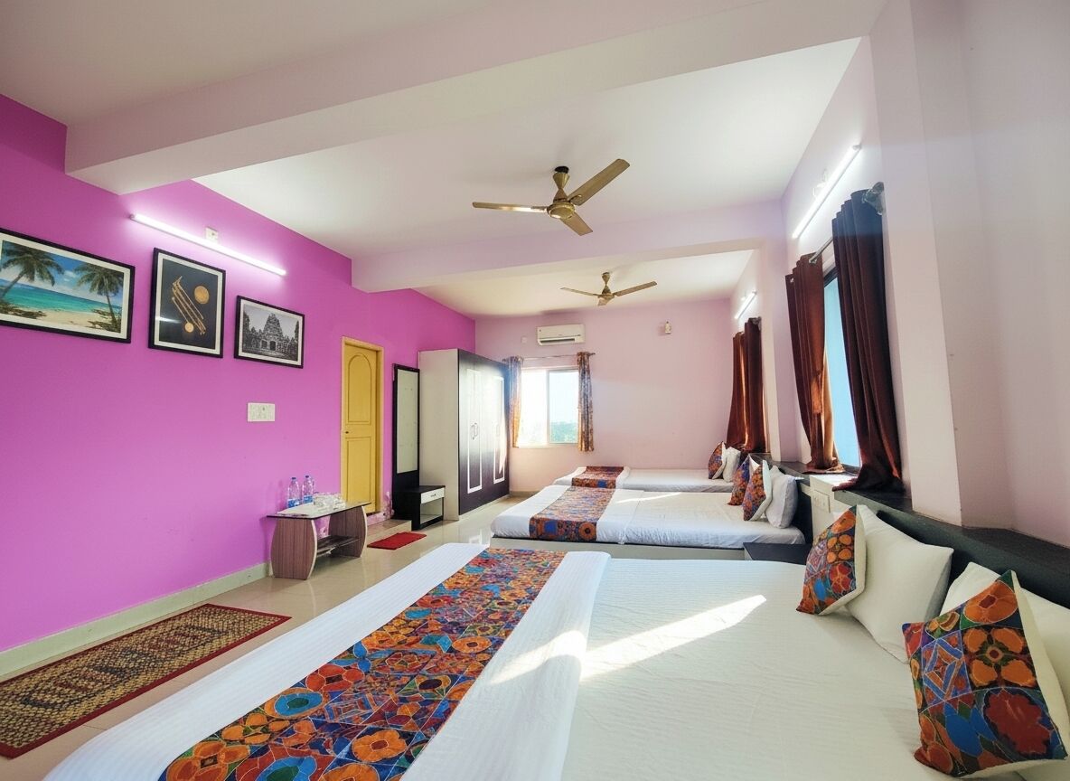 Habitación de hotel con dos camas, ventilador de techo, ventana con cortinas y pared decorada con cuadros.