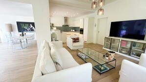 Un salon moderne avec un canapé, une table basse et un téléviseur.