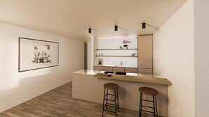 Een moderne keuken met een houten aanrecht, twee krukken en een lijst met een foto aan de muur.