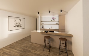 Une cuisine moderne avec un plan de travail en bois, deux tabourets et un tableau encadré au mur.