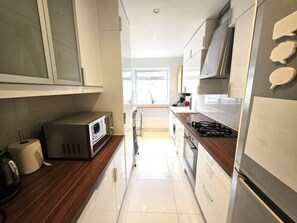 A modern kitchen with a microwave, stove, and oven. - Cosy 2BDR Flat in Leytonstone near Central Line (Greater London)
