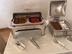 A buffet setup with various food items and utensils.