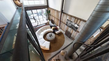 Een modern interieur met een glazen balustrade, een rond zitgedeelte en een grote metalen kolom.