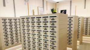 Eine Reihe aus Holz gefertigter Stauraumeinheiten mit nummerierten Fächern, vermutlich für die Gäste.