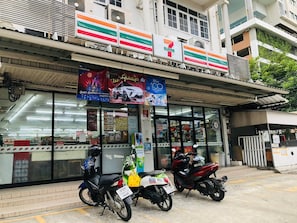 A 7-Eleven convenience store with motorcycles parked in front. - Room-supalai City Resort Changwattana (Pak Kret)