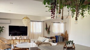 A modern living room with a dining area, a TV, and a kitchen island. - Gated Luxury Villa Private Pool & 24/7 Security in Vista Cana Punta Cana. (Punta Cana)