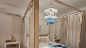 A four-poster bed with a wooden frame, a chandelier, a bedside table, and a nightstand. - Gated Luxury Villa Private Pool & 24/7 Security in Vista Cana Punta Cana. (Punta Cana)