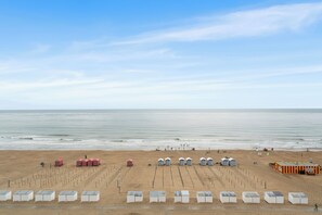 A beach with rows of beach huts and a sandy area. - 1 bedroom accommodation in De Panne (De Panne)