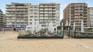 A multi-story hotel with outdoor seating, a beach view, and a storefront named 'Colosseo.' - 1 bedroom accommodation in De Panne (De Panne)