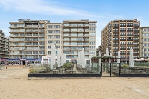 A multi-story hotel with outdoor seating, a beach view, and a storefront named 'Colosseo.' - 1 bedroom accommodation in De Panne (De Panne)