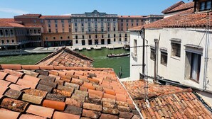 Vista de un edificio histórico con patio, canal y techo de tejas tradicionales.