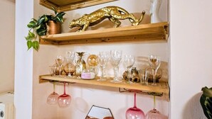 A wall-mounted shelf unit with decorative items and glassware. - 3 Bedroom Home on the Beautiful Trinity Square (Kent)