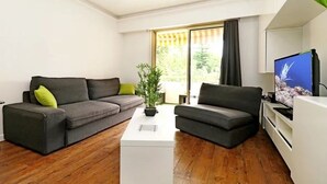 Un salon moderne avec deux canapés, une table basse et un téléviseur.