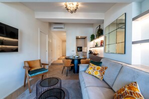 A modern living room with a sofa, chairs, a dining table, and a kitchen in the background. - Genteel Home Campuccio Firenze (Florence)