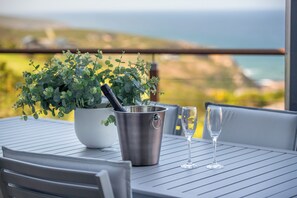 Ein Tisch mit einem Blumentopf, einem Metallkübel und zwei Weingläsern.