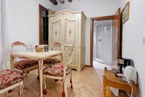 A dining area with a table, chairs, and a cabinet. - Apartment 'Venezia Baroque Charm' with Wi-Fi and Air Conditioning (Venice)