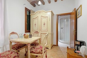 A dining area with a table, chairs, and a cabinet. - Apartment 'Venezia Baroque Charm' with Wi-Fi and Air Conditioning (Venice)