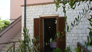 A stone building with a wooden door and a staircase leading up. - S378 - Sirolo, new one-bedroom apartment with garden and parking (Sirolo)