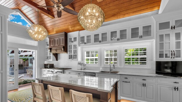 A spacious kitchen with a large island, white cabinetry, and a ceiling fan. - ~HELLO GORGEOUS~ Soak up the sun, swim in the pool, or relax in the jacuzzi! (Key West)