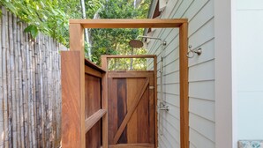 A wooden outdoor shower enclosure with a bamboo fence, a door, and a showerhead. - ~HELLO GORGEOUS~ Soak up the sun, swim in the pool, or relax in the jacuzzi! (Key West)