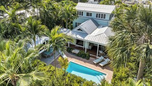 A large house with a swimming pool surrounded by lush greenery. - ~HELLO GORGEOUS~ Soak up the sun, swim in the pool, or relax in the jacuzzi! (Key West)